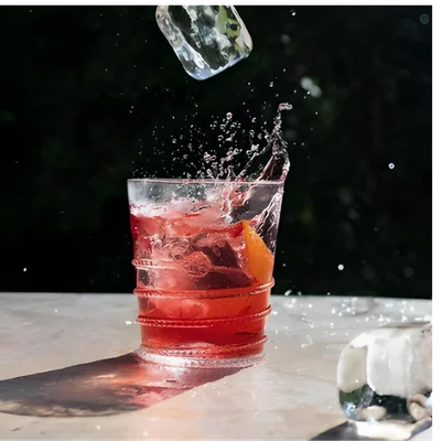 Cóctel rojo con hielo cayendo y salpicadura
